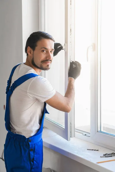 Worker installs the window and looks at the camera — Stock Photo, Image