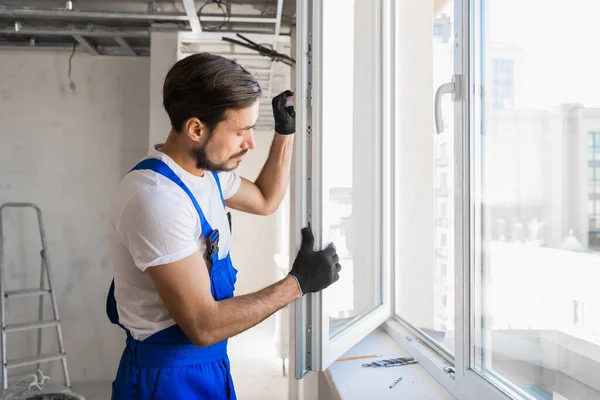 De bouwer inspecteert het raamkozijn en de vensterbank — Stockfoto