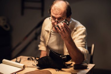 Tecrübeli bir kunduracı öğrencilerine stüdyoda aletlerle nasıl çalışacaklarını gösterir..