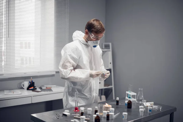 Conceito de Ciência e Pesquisa Química. Um cientista de roupas protetoras adicionando alguma substância ao queimador — Fotografia de Stock