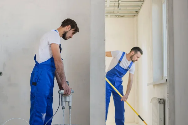 Dois trabalhadores fazem reparos no apartamento — Fotografia de Stock