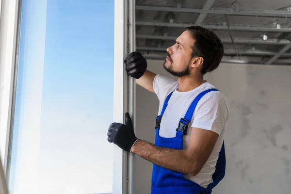 Reparador em luvas instala a janela no apartamento — Fotografia de Stock