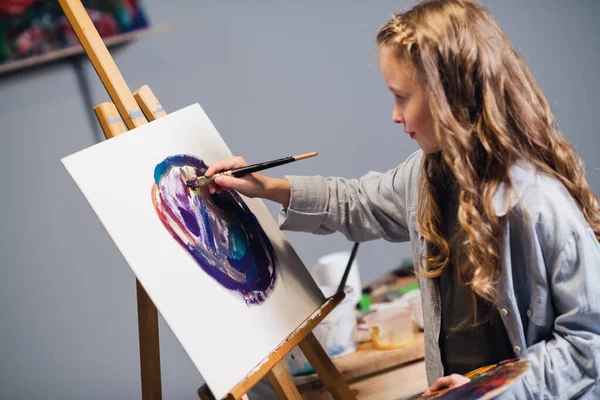 A little girl on vacation in her room draws an oil painting. An artist who is passionate about her hobby. — Stock Photo, Image