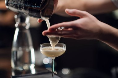 Lokantada masanın üzerinde duran nefis bir kokteylin olduğu bir bardağın yakın çekimi. Barmen kadınlar için alkollü bir içecek hazırlar.