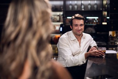 Yakışıklı bir adam barda güzel bir sarışın kız gördü ve ona gülümsedi.