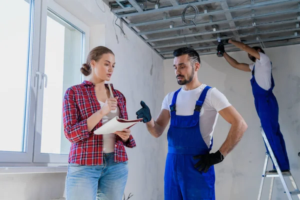 The woman checks the work of the foreman in the apartment and writes a note — Stock Photo, Image