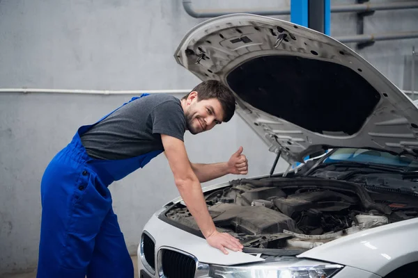 Bir tamirci yanında durur ve başparmağını gösterir.