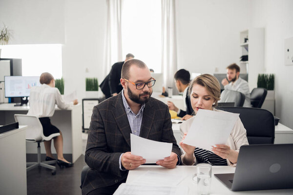 The business coach instructs trainees in a spacious office. Training of newcomers, internships in a large company.