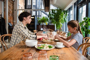 Güzel anne ve kız bir yemeği paylaşıyorlar.