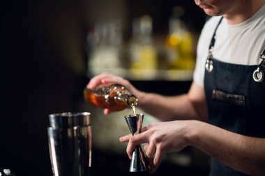 Deneyimli bir barmen alkollü kokteyl hazırlar. Yüz yok, yakın plan, kopyalama alanı.
