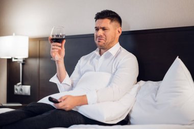 Yatağında bir kadeh şarapla sarhoş bir adam, pembe dizi izliyor ve...