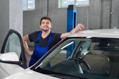 Bir atölye çalışanı arabanın yanında duruyor.