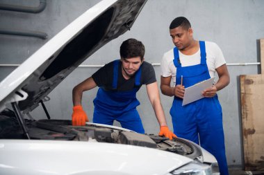 Bir tamirci, bir araç hakkında bir teknisyene danışıyor.