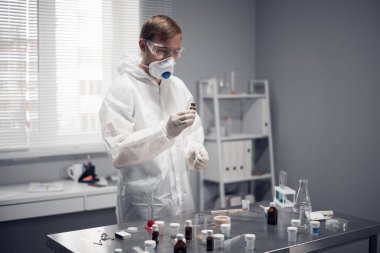 Genç bir öğrenci, kimyager, bir okul laboratuarında deney yapıyor.