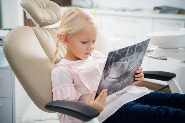 El dentista muestra a una pequeña paciente una radiografía de sus dientes — Foto de Stock