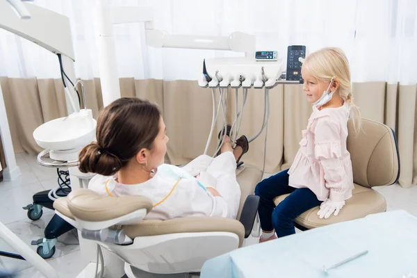 Un dentista experimentado está hablando con la chica tratando de establecer una — Foto de Stock