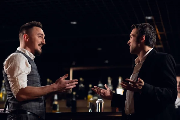 two male friends meet at the bar at the counter and communicate