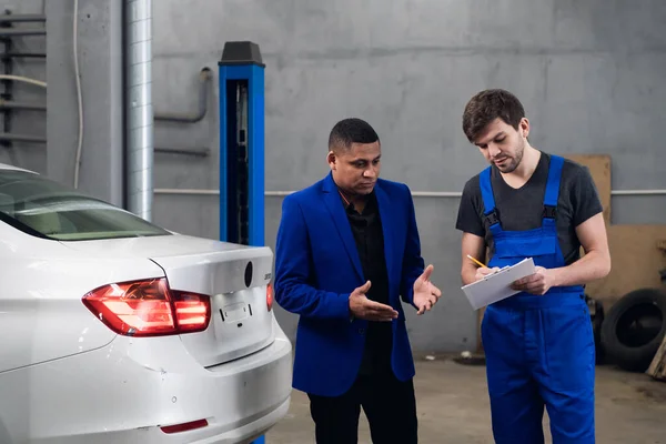 Car service worker talking to a customer about a repair