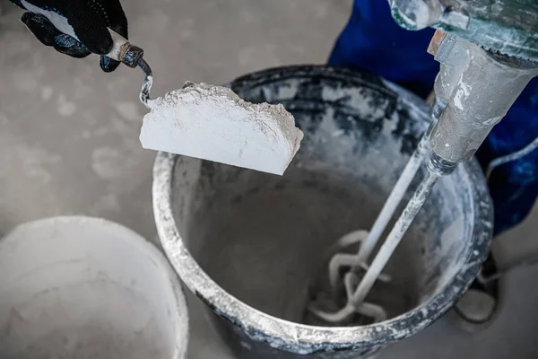 Reparaturfirma steckte trockenen Zement in einen Eimer mit Spachtel — Stockfoto