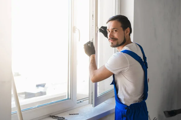 Man installerar fönstret och tittar på kameran — Stockfoto