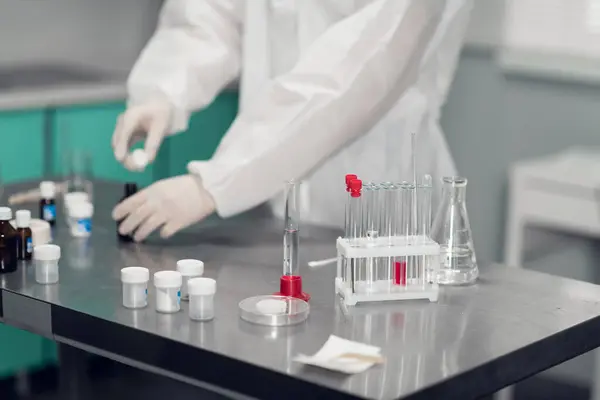 Close-up de uma mesa de laboratório com tubos de ensaio, líquidos, copos e outros equipamentos de laboratório — Fotografia de Stock