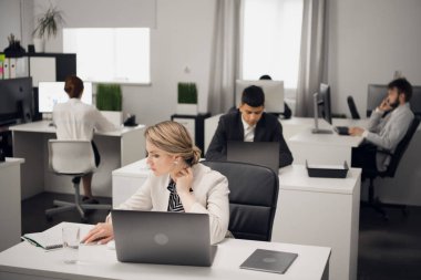 Müşteri hizmetleri müdürü masadaki iş yerinde dizüstü bilgisayarla..