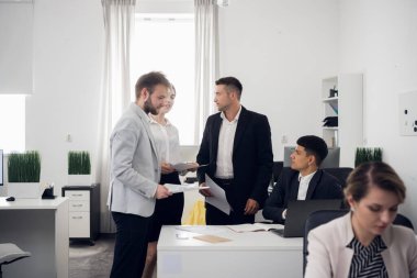 Kıdemli yöneticiler ve stajyerler İnsan Kaynakları şirketinin beyaz ofisinde bir toplantı yapıyorlar. Açık alan. Birkaç kişi..