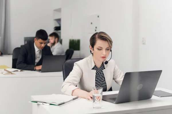 Pracownik call center siedzi przy biurku w biurze dużej firmy finansowej w ścisłym biurowym standardzie ubioru. — Zdjęcie stockowe