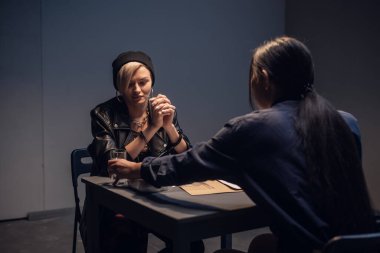 Şapkalı ve kaküllü sarışın bir kadın elinde bir çanta uyuşturucuyla sokakta yakalandı ve karakola götürüldü.