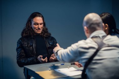 Sorgu odasında cinayete meyilli bir manyağın sorgulanması. Bir polis dedektifi bir şüpheliyle aynı masada oturuyor..