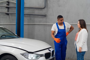 Tamirci ve müşteri arabanın motorunu inceleyin