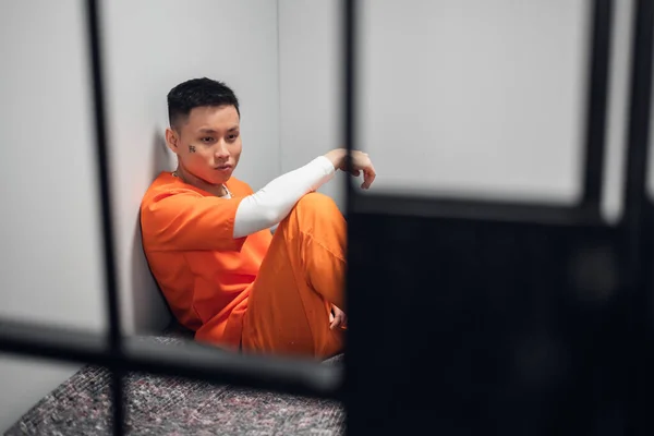 Um jovem criminoso ousado está preso na prisão. Depressão e apatia no confinamento solitário. — Fotografia de Stock