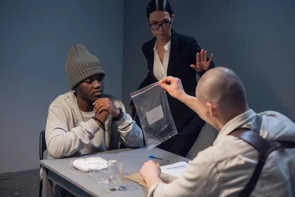 An experienced investigator during the interrogation shows the alleged criminal and his lawyer evidence of the crime committed