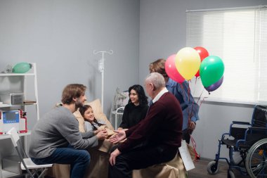 Küçük bir kız ve ailesi kazadan sonra hastane koğuşunda.