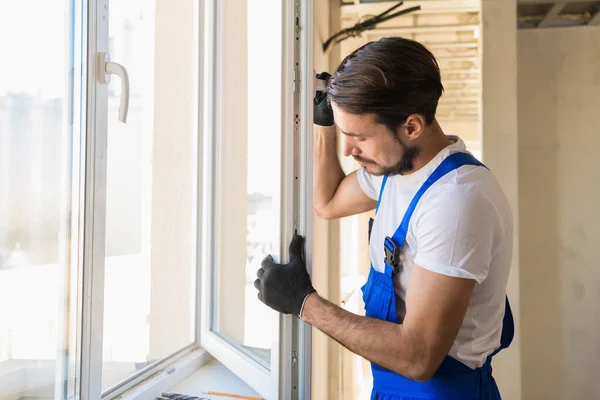 De reparateur inspecteert het raamkozijn en de vensterbank — Stockfoto