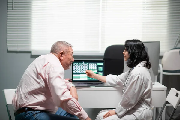 Médica geriatra explicando o diagnóstico para sua paciente idosa — Fotografia de Stock