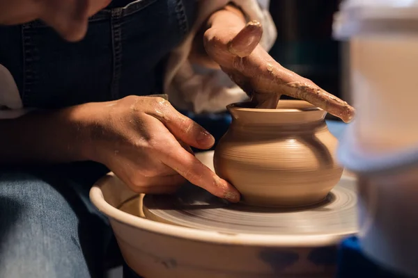 A master in a pottery workshop shows the technique of modeling a pot on a potters wheel. — Stock Photo, Image