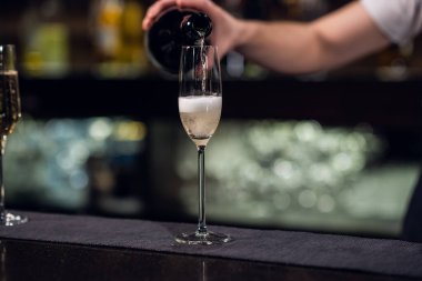 Bir şişeden dökülen bir kadeh şampanyaya yakından bakın.