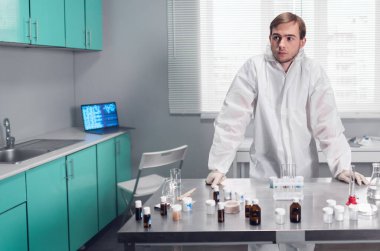 Araştırma merkezindeki bir laboratuvarın modern iç mimarisi. Koruyucu giysiler içinde bir laboratuar çalışanı masada duruyor.