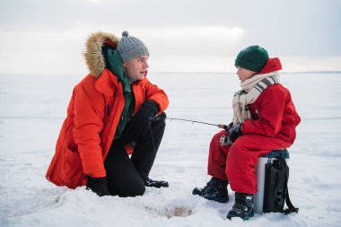 Tecrübeli bir balıkçı baba, küçük oğluna kışın balık avlamak için teçhizat kullanmayı öğretir..