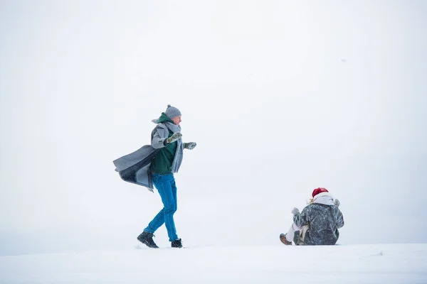 Во время прогулки зимой, парень и девушка веселятся в снежном поле — стоковое фото