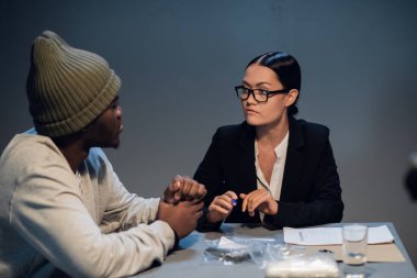 Genç ve güzel bir avukat kız Afro-Amerikan bir suçluyla konuşuyor.