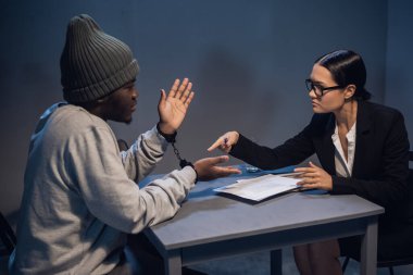 Zarif takım elbiseli güzel bir araştırmacı kız siyah bir suçludan soruşturmada işbirliği yapmasını ve itiraf imzalamasını istiyor..