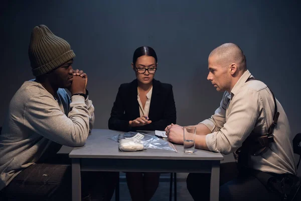 Um toxicodependente negro é interrogado numa esquadra por um investigador experiente e um advogado do governo. — Fotografia de Stock
