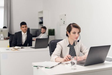 Müşteri hizmetleri müdürü masadaki iş yerinde dizüstü bilgisayarla..