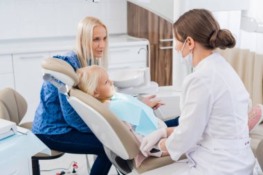 Kadın bir pediatrik diş uzmanı test sonuçlarını inceliyor.