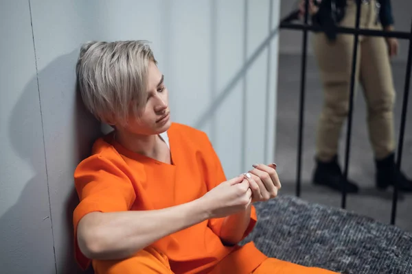 Smutná dívka zločinec přemýšlí o svém osudu, sedí na vězeňské posteli — Stock fotografie