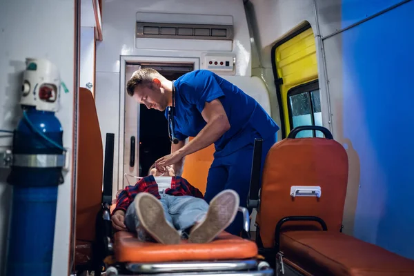 Un travailleur médical en uniforme bleu donne un masque à oxygène à une femme sauvée du feu — Photo