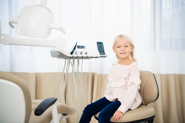Маленькая девочка сидит в стоматологическом кабинете — стоковое фото