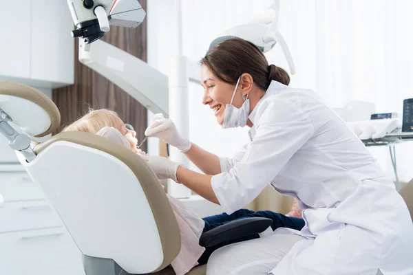 Een pediatrische tandheelkunde die de tanden van haar patiënt onderzoekt. Tandartspraktijk — Stockfoto